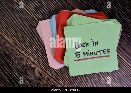 En 5 minutes, écrivez sur des notes adhésives isolées sur une table en bois. Banque D'Images