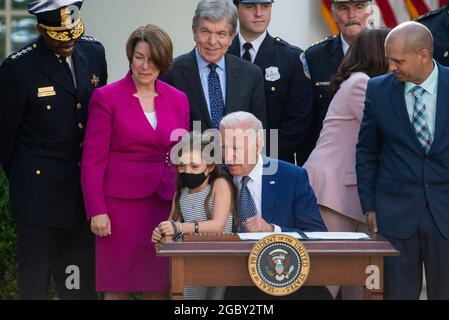 Abigail Evans, fille de William âBillyâ Evans, officier de police du Capitole tué, se joint au président des États-Unis Joe Biden, alors qu'il se prépare à signer le H.R. 3325, âAn Act pour décerner quatre médailles d'or au Congrès à la police du Capitole des États-Unis et à ceux qui ont protégé le Capitole des États-Unis le 6 janvier, 2021,â en droit dans le jardin des roses de la Maison Blanche à Washington, DC, le jeudi 5 août 2021. On y regarde la sénatrice américaine Amy Klobuchar (démocrate du Minnesota) et Roy Blunt (républicain du Missouri). Crédit : Rod Lamkey/CNP Banque D'Images