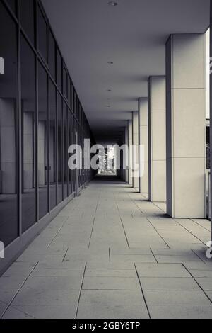 Plan vertical de plancher pavé sous le toit d'un bâtiment moderne entre les piliers et les fenêtres Banque D'Images