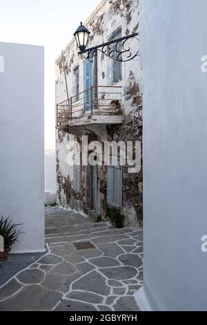 Île de Milos, Plaka Chora Cyclades Grèce. Ancienne maison en grès abandonnée pelée usée avec fenêtres en bois fermées entre les bâtiments blanchis à la chaux. COB Banque D'Images