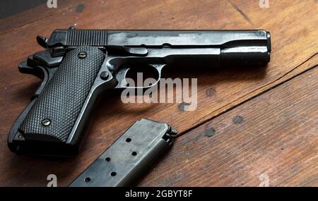 Pistolet 9 mm sur fond en bois. Arme à feu en métal noir, arme de poing automatique pour l'armée et la sécurité sur une table vintage. Vue latérale Banque D'Images