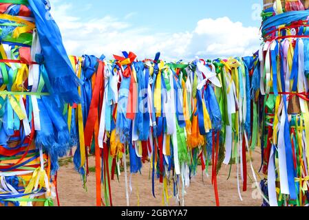 Rubans colorés sur des postes de culte du chamanisme à Khuzhir, île Olkhon. Banque D'Images