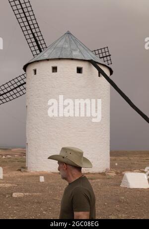 Un homme portant un chapeau de cow-boy avec des moulins à vent dans la campagne Banque D'Images