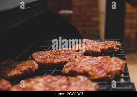 Hamburgers sur le gril avec le fromage gorm fondu sur la viande. Viande cuite sur le gril et charbon de bois. Chauffer sur la viande pour la cuisson. Viande grillée pour le bu Banque D'Images