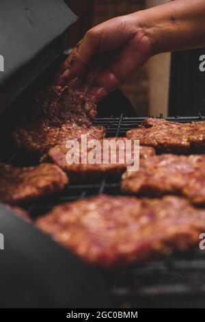 Hamburgers sur le gril avec le fromage gorm fondu sur la viande. Viande cuite sur le gril et charbon de bois. Chauffer sur la viande pour la cuisson. Viande grillée pour le bu Banque D'Images