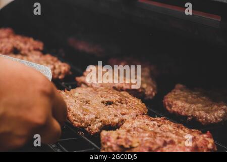 Hamburgers sur le gril avec le fromage gorm fondu sur la viande. Viande cuite sur le gril et charbon de bois. Chauffer sur la viande pour la cuisson. Viande grillée pour le bu Banque D'Images