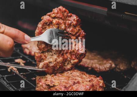 Hamburgers sur le gril avec le fromage gorm fondu sur la viande. Viande cuite sur le gril et charbon de bois. Chauffer sur la viande pour la cuisson. Viande grillée pour le bu Banque D'Images