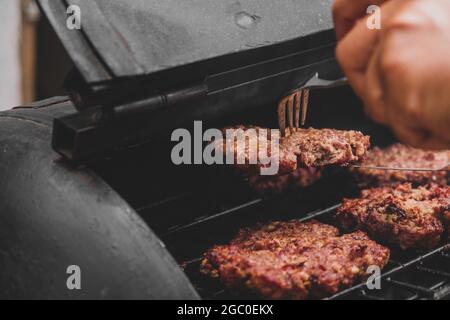 Hamburgers sur le gril avec le fromage gorm fondu sur la viande. Viande cuite sur le gril et charbon de bois. Chauffer sur la viande pour la cuisson. Viande grillée pour le bu Banque D'Images