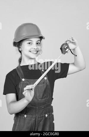 longueur. ouvrier de construction avec mètre ruban. Mignon enfant comme ouvrier de construction. Enfant répare la maison. Enfance heureuse. Auto-rétractable ruban en métal Banque D'Images