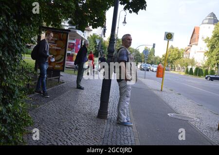 Attente du bus à l'arrêt de bus dans la soirée à Lindenthaler Allee, Mexikoplatz, à Zehlendorf, Berlin, Allemagne - 4 août 2021. Banque D'Images