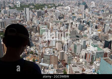 Silhouette d'un jeune garçon qui regarde la ville de Tokyo. Chiyoda Ward, Tokyo, Japon Banque D'Images