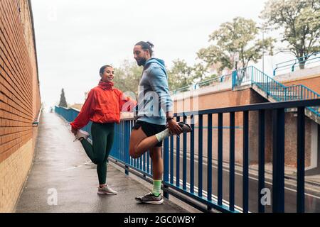 Une jeune femme et son amie portent des vêtements de sport qui s'étirent après avoir été à l'extérieur pendant les jours de pluie. Banque D'Images