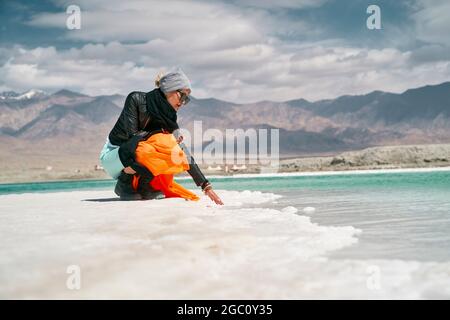 femme asiatique touriste touchant l'eau d'un lac salé Banque D'Images