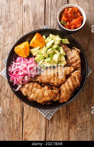 POC CHUC Yucatecan Grilled Pork est un plat traditionnel maya mariné dans le jus d'orange aigre et servi avec des oignons marinés et l'avocat closeup dans le p Banque D'Images