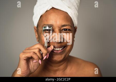 Bonne femme africaine senior utilisant le fard à paupières - personnes beauté et bien-être concept de style de vie Banque D'Images