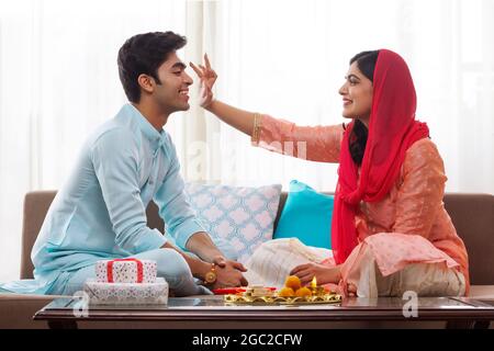 HEUREUX FRÈRES ET SŒURS SUIVANT LES RITUELS RAKSHABANDHAN À LA MAISON Banque D'Images