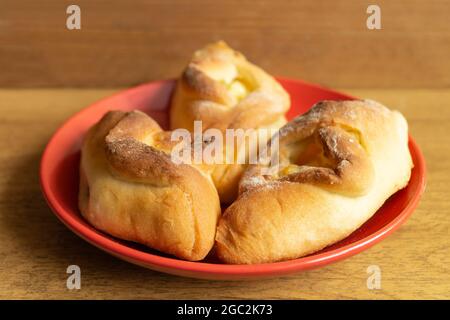 Croissants faits maison dans une assiette rouge sur la table. Gros plan sur les produits frais Banque D'Images