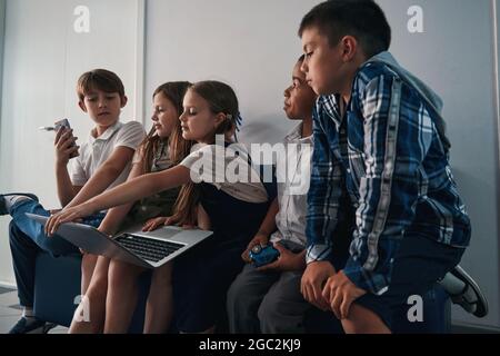 Les enfants apprécient de passer du temps en ligne ensemble à l'école Banque D'Images