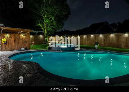 Une piscine arrière et un jacuzzi chaud tob la nuit Banque D'Images