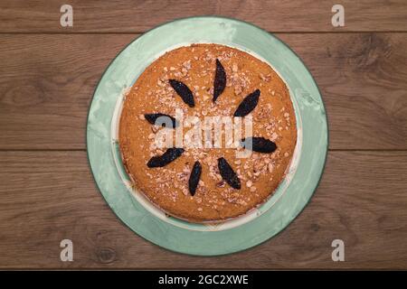 Gâteau au miel maison avec crème, noix et pruneaux sur une table en bois. Vue de dessus Banque D'Images