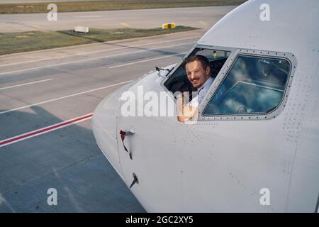 Aviateur joyeux posant pour la caméra depuis la plate-forme de vol Banque D'Images