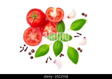 ​​tomato entier et coupé en tranches avec feuilles de basilic et ail, épice isolée sur fond blanc. Vue de dessus avec espace de copie Banque D'Images