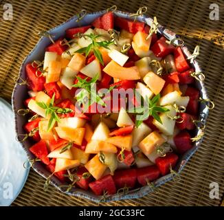 Grand plat de fruits frais coupés, melon, pastèque, sur des bâtonnets de bambou. Banque D'Images