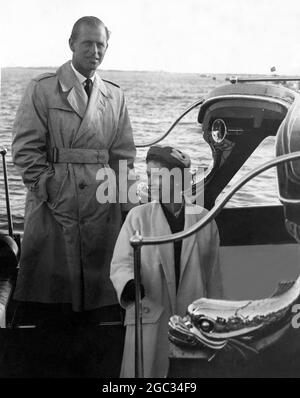 Reine et duc ensemble au Portugal HM la Reine et le duc d'Édimbourg, vus comme ils retournent dans la barge royale à la Britannia après avoir déjeuné officieusement avec le duc et la duchesse de Palmela hier. Ils naviguent dans le Britannia à Lisbonne ce matin pour commencer leur visite d'État au Portugal. 18 février 1957 Banque D'Images