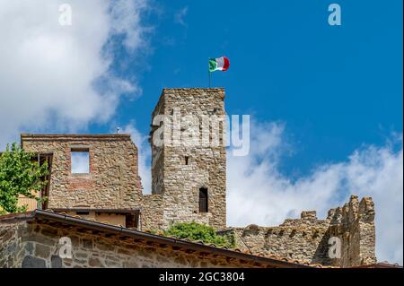 Le drapeau italien survole la forteresse médiévale de Passignano sul Trasimeno, Ombrie, Italie Banque D'Images