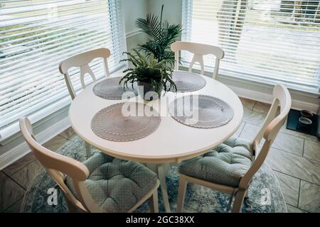 Gros plan d'une petite table et de quatre chaises dans une cuisine avec un sol carrelé Banque D'Images