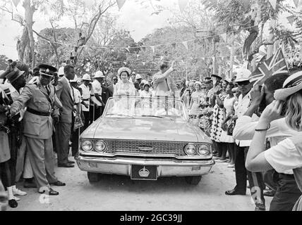 Barbade : Grande-Bretagne la reine Elizabeth II et le prince Philip Duke d'Édimbourg, actuellement en tournée de cinq semaines dans les Caraïbes, sont photographiés en voiture à travers Queens Park après leur arrivée à la Barbade, le 14 février. 16 février 1966 Banque D'Images