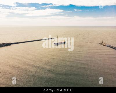 Vue panoramique aérienne cargo entrant dans le port de Klaipeda en Lituanie avec un vaste fond de mer Banque D'Images