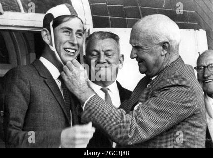 Un grand sourire du prince Charles alors qu'il devient un « maître-nageur » de Bondi. Il est photographié avec l'aide de la casquette rouge, blanche et de couleur chocolat du Sydney Surf Club présentée par Kerwin MacGraith , directeur du North Bondi Surf Life Saving Club dans le cadre de la cérémonie faisant de lui un membre honoraire. 25 mai 1966 Banque D'Images