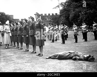 Pendant que la princesse Elizabeth inspectait la garde d'honneur de la WRAC lors de sa visite au spectacle de la Société royale d'agriculture à Shrewsbury, un sergent membre de la garde s'est évanoui vu allongé sur le terrain pendant que la princesse effectue l'inspection le 1949 juillet Banque D'Images