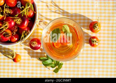 Thé aux hanches roses et fruits de rose sauvages dans un bol. Gros plan. Banque D'Images