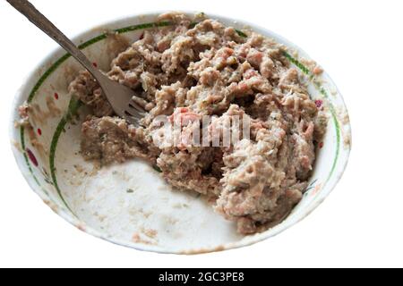 viande hachée dans une assiette blanche, préparée à partir de porc, de boeuf, d'oignons et d'épices. Fourche Forcemeat. Isolez la fabrication des tartes. Banque D'Images