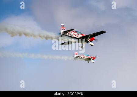 Petite et grande équipe d'exposition Extra Duo effectuant une fantastique routine acrobatique au Shuttleworth Family Airshow le 1er août 2021 Banque D'Images