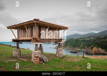 Grange dans un pré avec les falaises du nord de l'Espagne et la mer Cantabrique en arrière-plan Banque D'Images