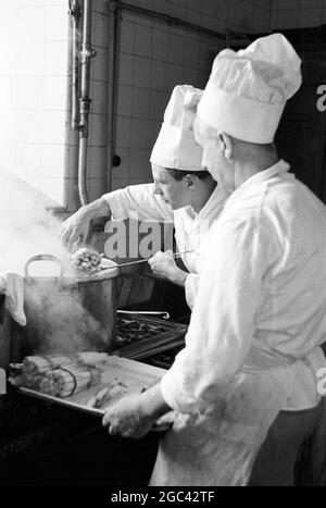 Dans les coulisses d'un banquet d'État. Banquet de retour pour la reine Elizabeth II au Mansion House, Londres, après sa visite du Commonwealth en 1954. La société de restauration de Ring & Brymer (Birch's) Ltd a géré la restauration à chaque banquet de Coronation donné par la Corporation of London depuis le Coronation de la reine Victoria et a occupé plus de têtes couronnées que n'importe quelle autre entreprise du monde. 19 mai 1954 photos : deux chefs cuisiniers cuisinent les asperges Banque D'Images