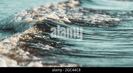 Une vague qui se déroule de la mer sombre de la mer Baltique et donne de belles lignes dans l'eau sombre. Banque D'Images