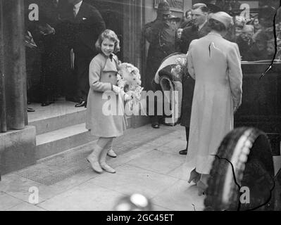 La princesse Elizabeth a retourné la vague d'un passant lorsqu'elle a quitté le Central Hall, Westminster, avec la reine et la princesse Margaret Rose après avoir assisté au concert de Coronation pour enfants. La princesse Elizabeth rentrant la vague de personnes rassemblées à l'extérieur de la salle centrale Ashley a quitté avec la reine et la princesse Margaret. 6 avril 1937 Banque D'Images