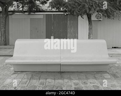 Banc en béton vide monochrome sur le trottoir urbain Banque D'Images