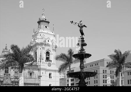 Statue en bronze monochrome de la fontaine sur la Plaza Mayor Square avec la cathédrale de Lima en arrière-plan, Lima, Pérou Banque D'Images