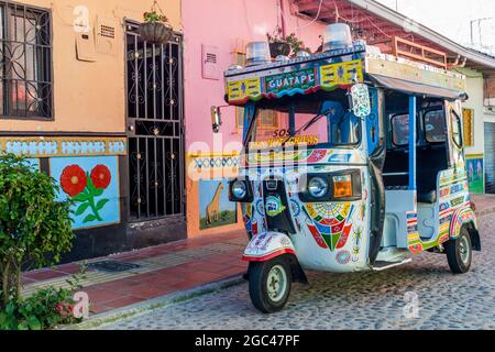 GUATAPE, COLOMBIE - 2 SEPTEMBRE 2015 : mototaxi coloré (tuk tuk) et maisons décorées dans le village de Guatape, Colombie Banque D'Images