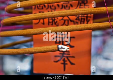 Une grande bobine d'encens suspendus brûle au temple de Hong Kong, en Chine Banque D'Images