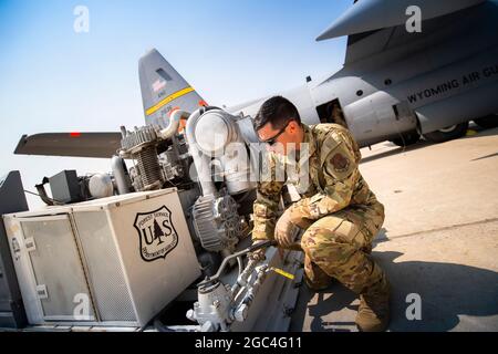 Les membres affectés à la 153d Airlift Wing préparent et chargent un avion C-130 Hercules avec un système de lutte contre l'incendie aéroporté modulaire (MAFFS) à la base de la Garde nationale aérienne du Wyoming, Cheyenne (Wyo.), le 19 juillet 2021. Le Service forestier de l'USDA a activé l'avion C-130H équipé de la MAFFS par le biais d'une demande d'assistance du Département de la Défense et sera en opération à partir de McClellan Park, en Californie, les équipes de la MAFFS sont gérées par le 153e groupe expéditionnaire aérien de la First Air Force (Air Forces Northern). (É.-U. Photo de la Garde nationale aérienne par Tech. Sgt. Jon Alderman) Banque D'Images