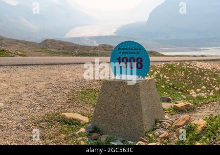 Glacier d'Athabasca avec un panneau indiquant l'effet du changement climatique sur la fonte des glaces depuis 1908, avec des feux de forêt qui fument dans l'air, Alberta, Canada. Banque D'Images