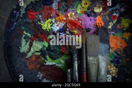 Matériel de peinture à l'eau pinceaux de différentes tailles, palettes de couleurs sur fond en bois ancien. Banque D'Images