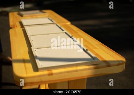 Les cadres photo sont sur la table. Les cadres photo sont préparés pour la cérémonie de remise des prix. Ébauches pour certificats de cadres en bois. Table en bois à l'extérieur Banque D'Images