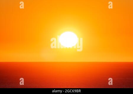 Le soleil vient de s'élever au-dessus de l'horizon au-dessus de la mer lors d'une journée d'été. Banque D'Images